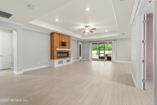 3024 Las Calinas Blvd, Saint Augustine, FL 32095 - unfurnished living room featuring a tray ceiling, ceiling fan, ornamental molding, a fireplace, and recessed lighting