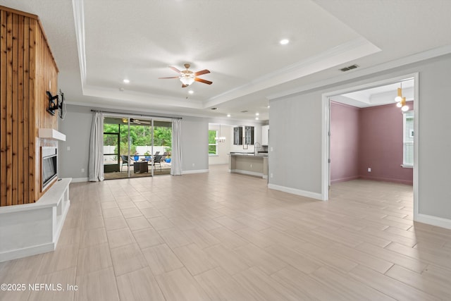3024 Las Calinas Blvd, Saint Augustine, FL 32095 - unfurnished living room with a raised ceiling, ceiling fan, crown molding, a glass covered fireplace, and recessed lighting