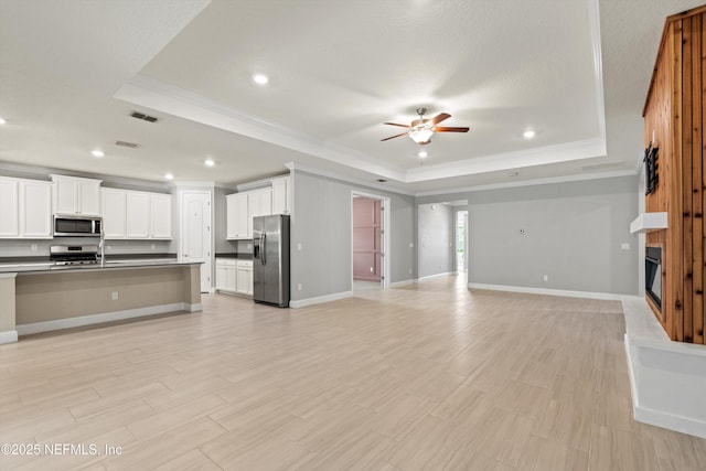 3024 Las Calinas Blvd, Saint Augustine, FL 32095 - unfurnished living room featuring a tray ceiling, ornamental molding, a fireplace, ceiling fan, and recessed lighting
