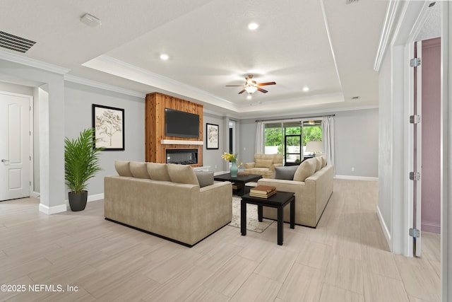 3024 Las Calinas Blvd, Saint Augustine, FL 32095 - living room featuring a raised ceiling, a ceiling fan, ornamental molding, recessed lighting, and a fireplace