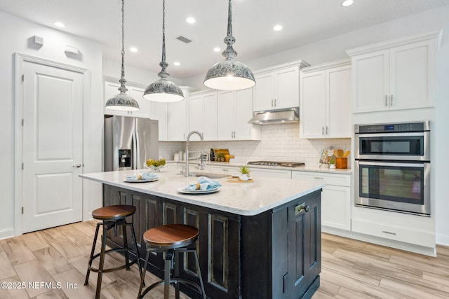 21 Mollusk Rd, Saint Johns, FL 32259 - kitchen with appliances with stainless steel finishes, under cabinet range hood, white cabinets, tasteful backsplash, and recessed lighting
