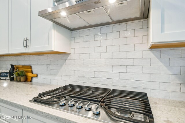 21 Mollusk Rd, Saint Johns, FL 32259 - kitchen with stainless steel gas stovetop, range hood, white cabinetry, decorative backsplash, and light stone countertops