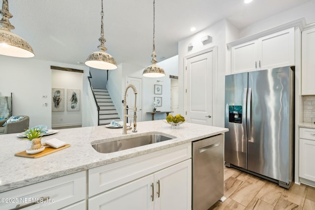 21 Mollusk Rd, Saint Johns, FL 32259 - kitchen with stainless steel appliances, white cabinetry, hanging light fixtures, light stone countertops, and recessed lighting