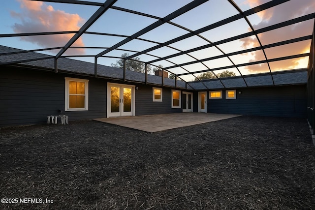2181 Glenwood Hammock Rd, Deland, FL 32720 - back of house at dusk featuring a patio, glass enclosure, a chimney, and french doors