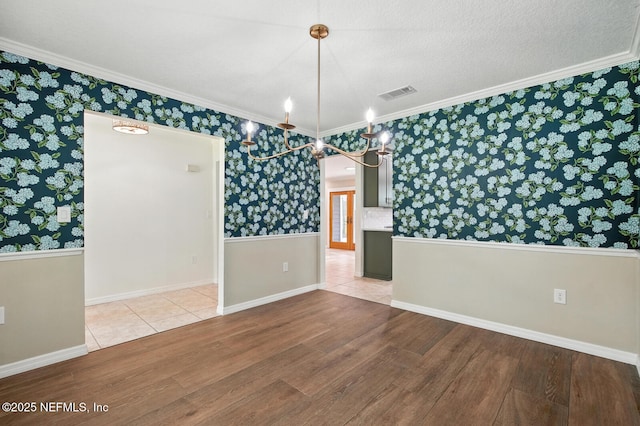 2181 Glenwood Hammock Rd, Deland, FL 32720 - empty room featuring wallpapered walls, a chandelier, wood finished floors, and ornamental molding