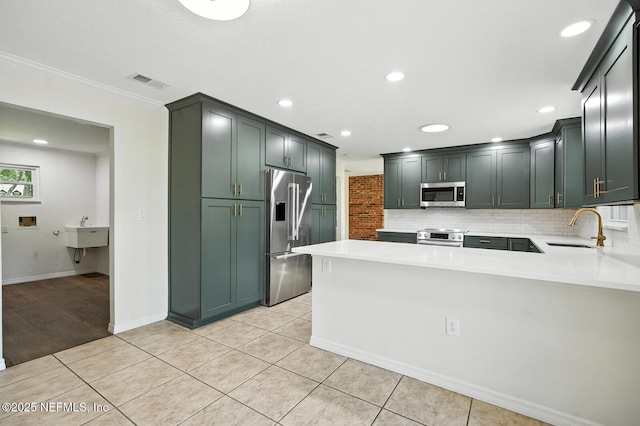 2181 Glenwood Hammock Rd, Deland, FL 32720 - kitchen featuring appliances with stainless steel finishes, a peninsula, light countertops, tasteful backsplash, and recessed lighting