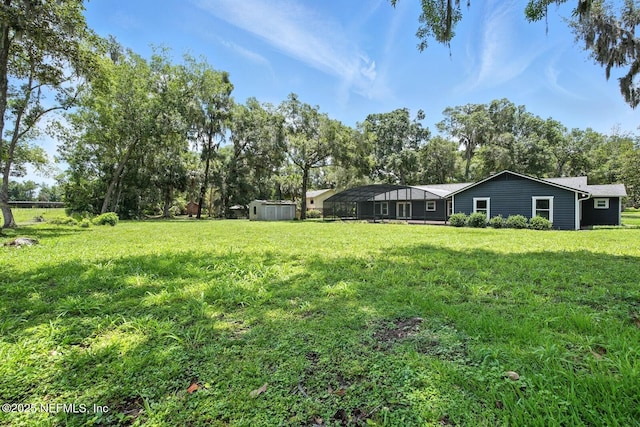 2181 Glenwood Hammock Rd, Deland, FL 32720 - view of green lawn featuring a storage unit and view of wooded area