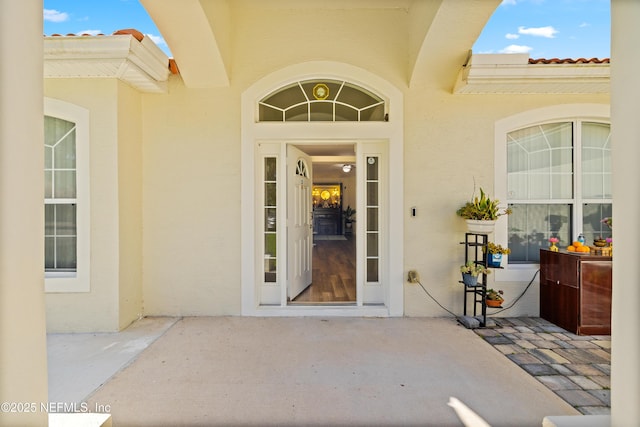 8 Village Cir, Palm Coast, FL 32164 - view of exterior entry with stucco siding and a tiled roof