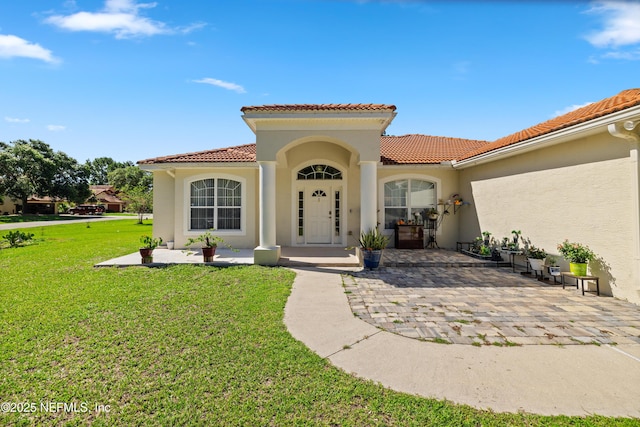 8 Village Cir, Palm Coast, FL 32164 - doorway to property featuring stucco siding, a yard, and a tiled roof