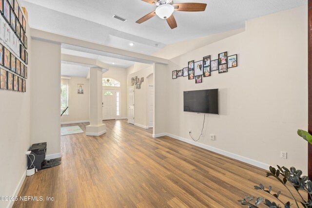 8 Village Cir, Palm Coast, FL 32164 - unfurnished living room with a ceiling fan, wood finished floors, recessed lighting, lofted ceiling, and decorative columns