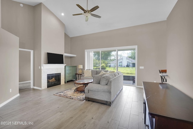 1571 Shelter Cove Dr, Fleming Island, FL 32003 - living area featuring high vaulted ceiling, a ceiling fan, a stone fireplace, and light wood-type flooring