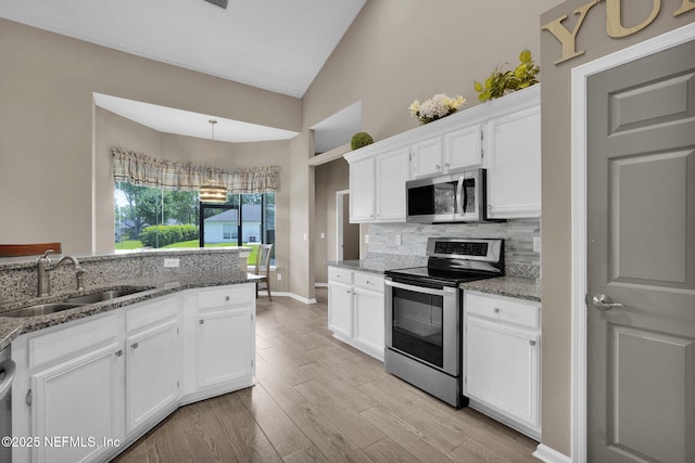 1571 Shelter Cove Dr, Fleming Island, FL 32003 - kitchen with stainless steel appliances, backsplash, white cabinets, high vaulted ceiling, and light stone counters