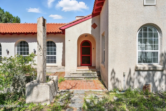 150 Calle Menendez, Saint Augustine, FL 32086 - entrance to property with stucco siding, a tiled roof, and a chimney