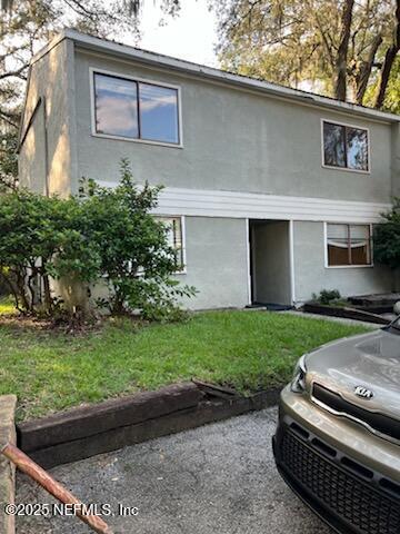 714 Oaks Manor Ct Unit M3-2, Jacksonville, FL 32211 - view of home's exterior featuring stucco siding and a yard