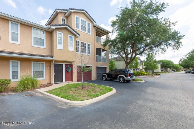 10075 Gate Pkwy N Unit 913, Jacksonville, FL 32246 - view of front of home featuring asphalt driveway, stucco siding, and a garage