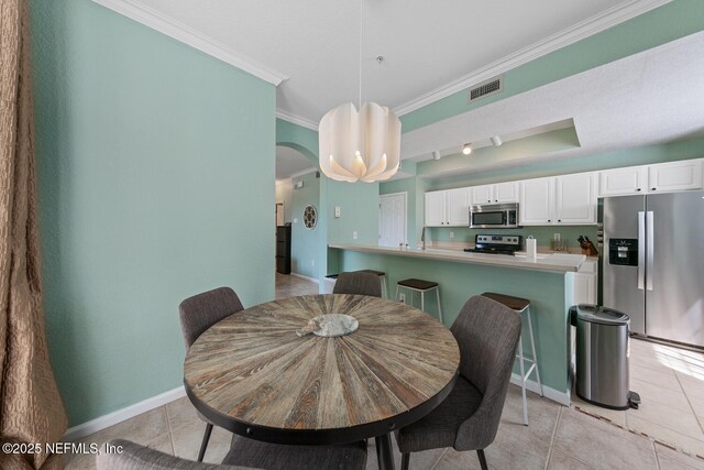 10075 Gate Pkwy N Unit 913, Jacksonville, FL 32246 - dining space featuring light tile patterned floors, crown molding, and arched walkways