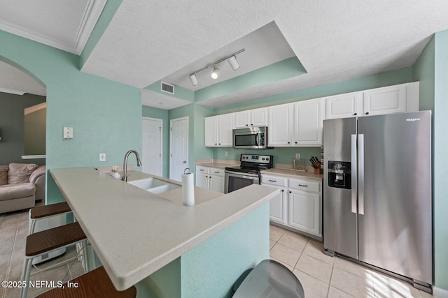 10075 Gate Pkwy N Unit 913, Jacksonville, FL 32246 - kitchen with stainless steel appliances, light tile patterned floors, a breakfast bar, white cabinetry, and a textured ceiling