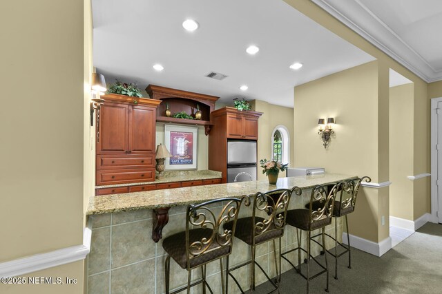 10075 Gate Pkwy N Unit 913, Jacksonville, FL 32246 - kitchen with freestanding refrigerator, a peninsula, light stone counters, a breakfast bar, and recessed lighting