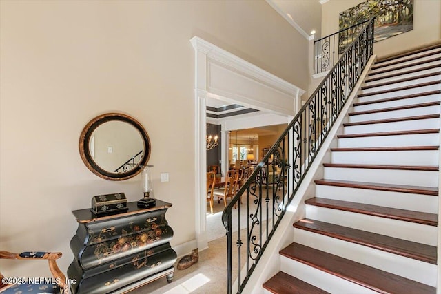 4705 Sawbuck St, Saint Augustine, FL 32092 - staircase featuring a chandelier, crown molding, and carpet floors
