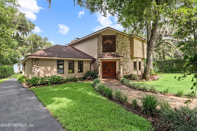 970 Fruit Cove Rd, Saint Johns, FL 32259 - mid-century modern home with stone siding, a front lawn, and french doors