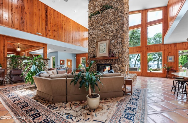 970 Fruit Cove Rd, Saint Johns, FL 32259 - living area with a high ceiling, wood walls, a stone fireplace, and tile patterned floors