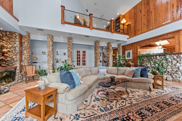 970 Fruit Cove Rd, Saint Johns, FL 32259 - living area featuring a towering ceiling, a stone fireplace, tile patterned floors, and wood walls