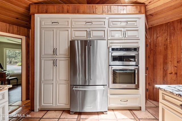 970 Fruit Cove Rd, Saint Johns, FL 32259 - kitchen with stainless steel appliances, wood walls, wood ceiling, light stone countertops, and cream cabinetry
