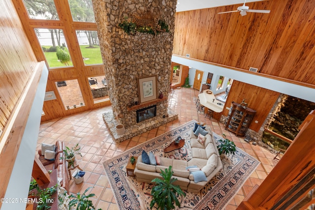 970 Fruit Cove Rd, Saint Johns, FL 32259 - tiled living area featuring wooden walls, a stone fireplace, and ceiling fan