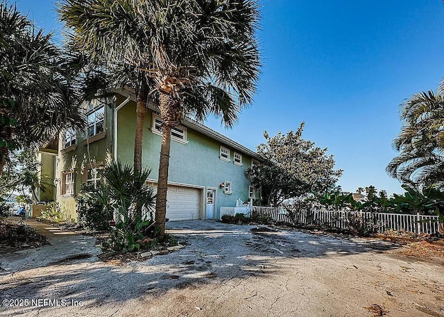 5903 Bimini Way N, Saint Petersburg, FL 33706 - view of home's exterior featuring stucco siding, a garage, and driveway