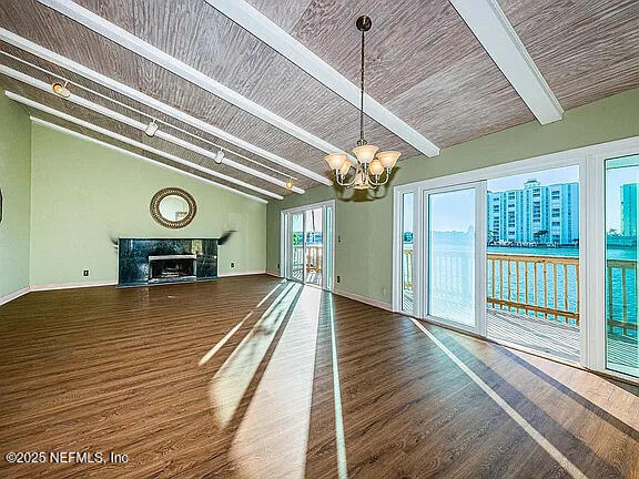 5903 Bimini Way N, Saint Petersburg, FL 33706 - unfurnished living room featuring a chandelier, wood finished floors, and a premium fireplace