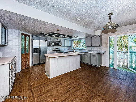 5903 Bimini Way N, Saint Petersburg, FL 33706 - kitchen featuring appliances with stainless steel finishes, a textured ceiling, gray cabinets, light countertops, and dark wood finished floors