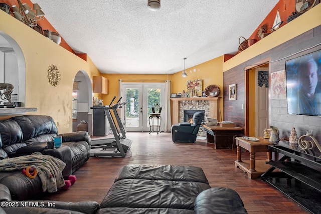 1942 Calusa Trl, Middleburg, FL 32068 - living room with a textured ceiling, arched walkways, vaulted ceiling, wood finished floors, and a fireplace
