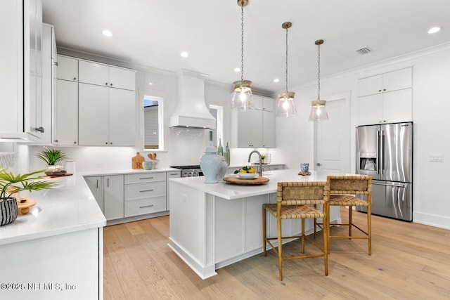 1501 Emma Ln, Neptune Beach, FL 32266 - kitchen featuring stainless steel fridge with ice dispenser, custom exhaust hood, light wood-type flooring, light countertops, and a center island with sink