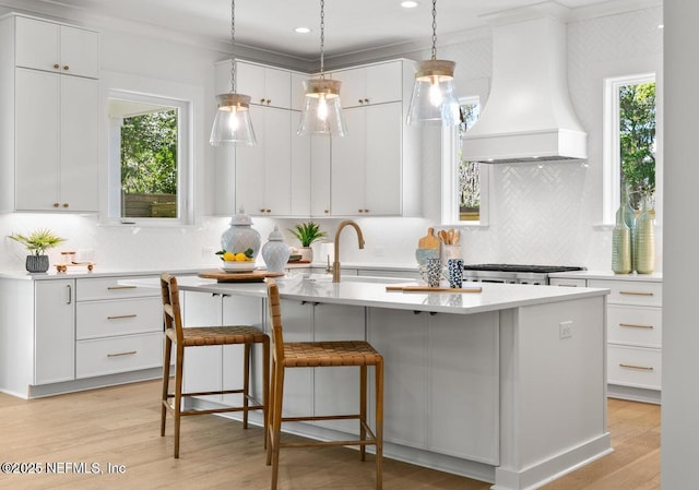 1501 Emma Ln, Neptune Beach, FL 32266 - kitchen with custom exhaust hood, light countertops, white cabinetry, light wood-style floors, and recessed lighting