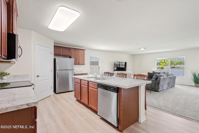 189 Blue Creek Way, Saint Augustine, FL 32086 - kitchen featuring appliances with stainless steel finishes, open floor plan, light countertops, light wood finished floors, and a textured ceiling