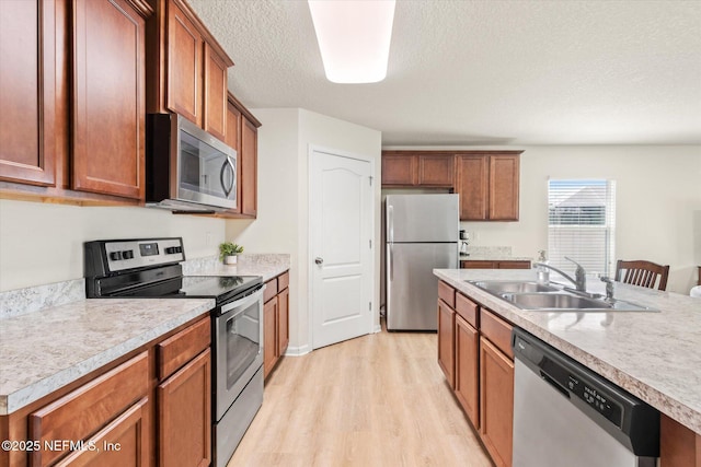 189 Blue Creek Way, Saint Augustine, FL 32086 - kitchen with stainless steel appliances, light wood-style floors, light countertops, brown cabinetry, and a textured ceiling