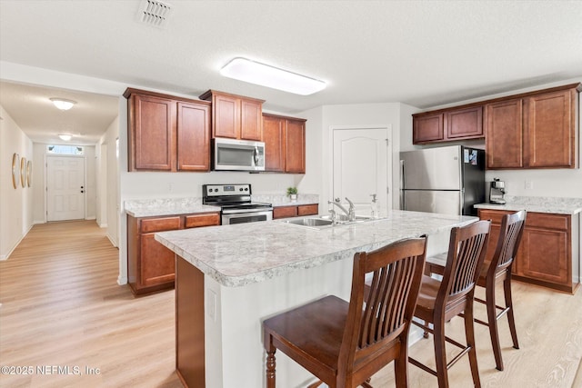 189 Blue Creek Way, Saint Augustine, FL 32086 - kitchen with appliances with stainless steel finishes, light wood-type flooring, a breakfast bar, and light countertops