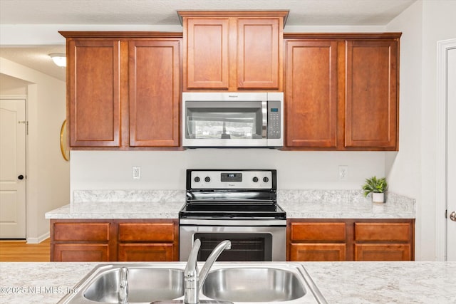 189 Blue Creek Way, Saint Augustine, FL 32086 - kitchen featuring stainless steel appliances, light countertops, brown cabinetry, and wood finished floors