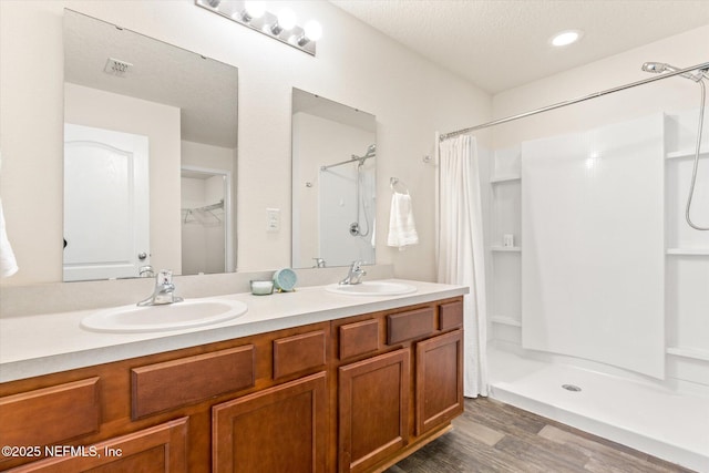189 Blue Creek Way, Saint Augustine, FL 32086 - bathroom featuring curtained shower, wood finished floors, double vanity, and a spacious closet