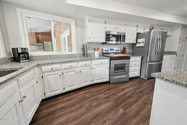361 SE 34th St, Keystone Heights, FL 32656 - kitchen featuring appliances with stainless steel finishes, light stone countertops, white cabinetry, and dark wood finished floors