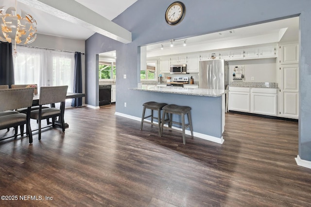 361 SE 34th St, Keystone Heights, FL 32656 - kitchen featuring appliances with stainless steel finishes, white cabinets, a peninsula, light stone counters, and a chandelier