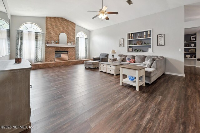361 SE 34th St, Keystone Heights, FL 32656 - living room featuring ceiling fan, vaulted ceiling, built in shelves, dark wood-style floors, and a brick fireplace