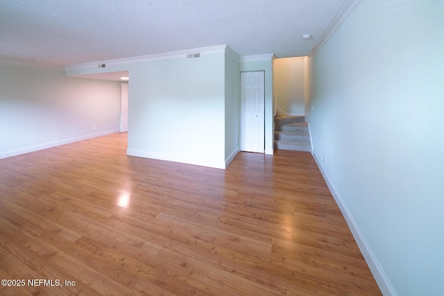 100 Fairway Park Blvd Unit 1004, Ponte Vedra Beach, FL 32082 - empty room featuring ornamental molding, stairs, a textured ceiling, light wood finished floors, and a smoke detector