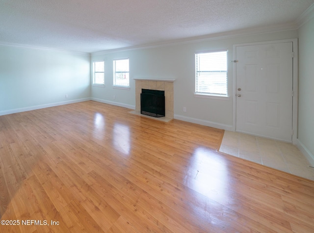 100 Fairway Park Blvd Unit 1004, Ponte Vedra Beach, FL 32082 - unfurnished living room with crown molding, a tiled fireplace, light wood-type flooring, and a textured ceiling
