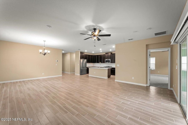 75570 Pondside Ln, Yulee, FL 32097 - unfurnished living room featuring ceiling fan, a chandelier, and light wood-style flooring