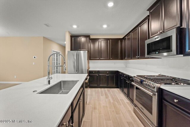 75570 Pondside Ln, Yulee, FL 32097 - kitchen with stainless steel appliances, light countertops, recessed lighting, dark brown cabinets, and light wood-type flooring