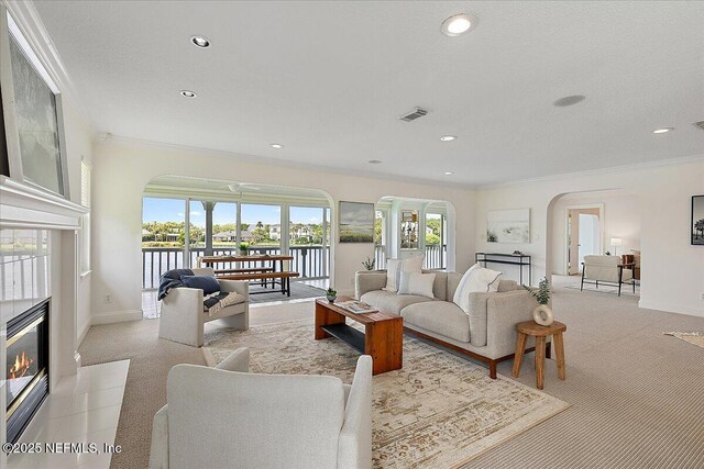 91 San Juan Dr Unit E3, Ponte Vedra Beach, FL 32082 - living room with arched walkways, a glass covered fireplace, carpet, crown molding, and recessed lighting