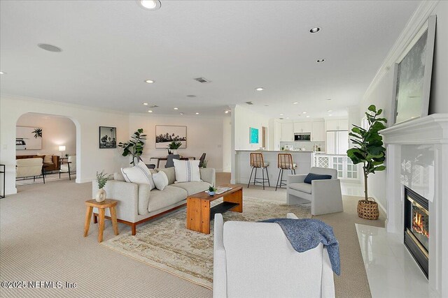 91 San Juan Dr Unit E3, Ponte Vedra Beach, FL 32082 - living room with arched walkways, crown molding, recessed lighting, a fireplace, and light carpet