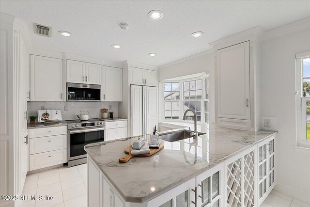91 San Juan Dr Unit E3, Ponte Vedra Beach, FL 32082 - kitchen featuring stainless steel appliances, plenty of natural light, white cabinetry, decorative backsplash, and recessed lighting