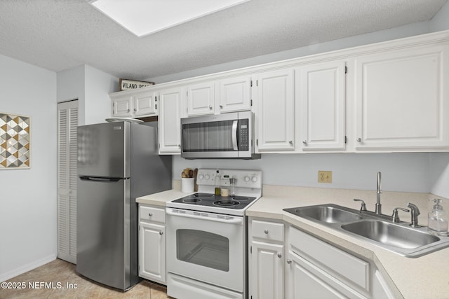 110 Ocean Hollow Ln Unit 114, Saint Augustine, FL 32084 - kitchen featuring appliances with stainless steel finishes, light countertops, white cabinetry, light tile patterned flooring, and a textured ceiling